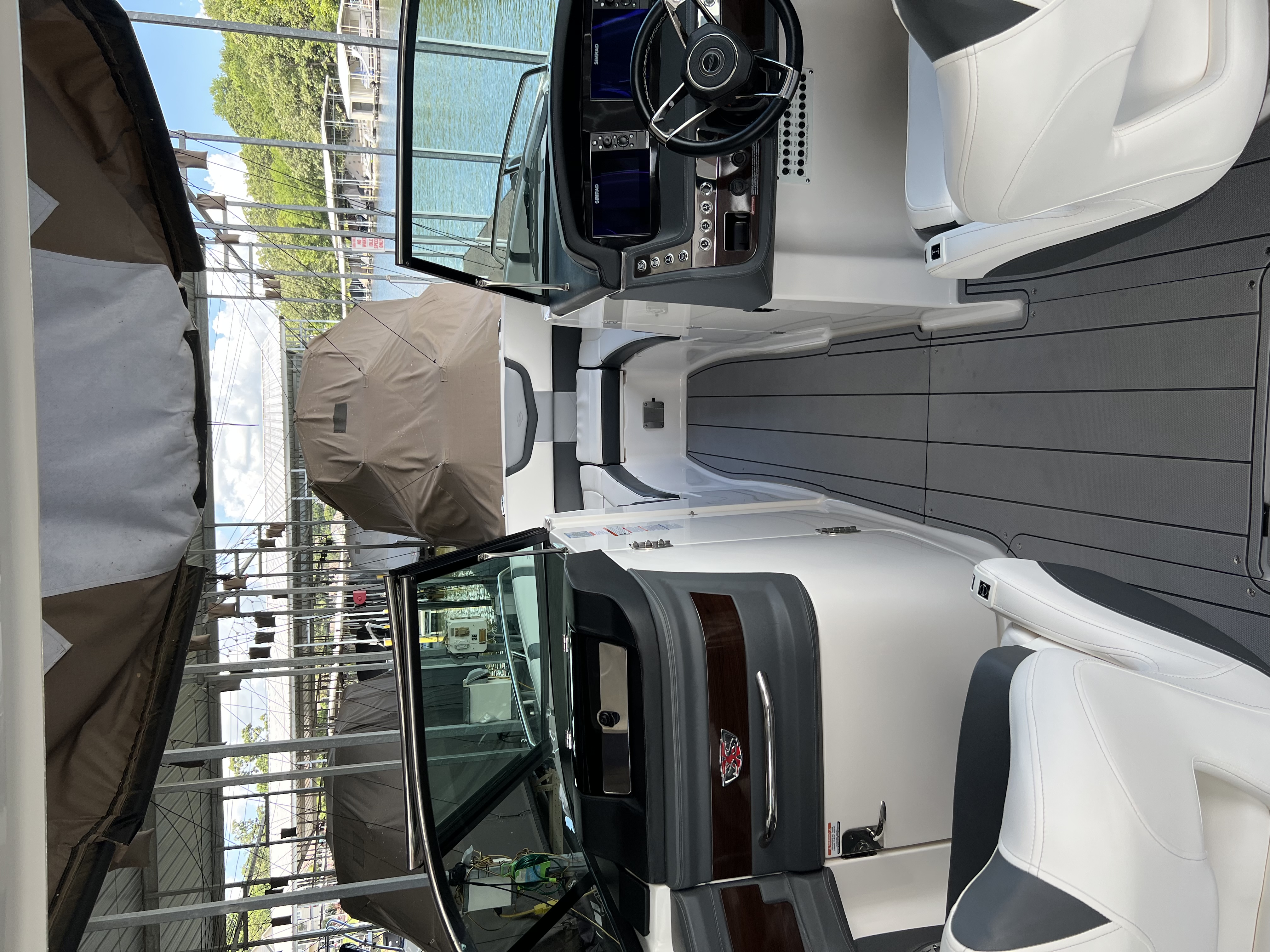 Detailed white and gray bowrider interior with dual helm displays and teak-look floor